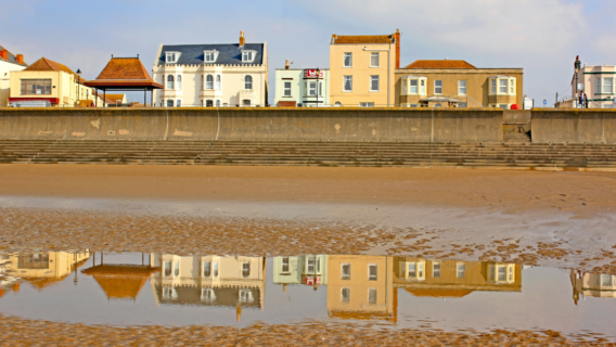 Seafront houses and their reflection on wet sand at low tide in Burnham-on-Sea, Somerset