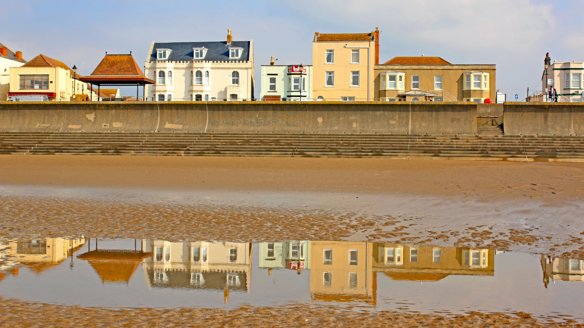 Seafront houses and their reflection on wet sand at low tide in Burnham-on-Sea, Somerset