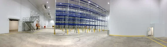 Interior of a large cold storage warehouse with high-bay racking, illustrating the scale of building typically tested for commercial airtightness