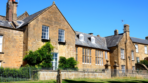 Grade-listed Hamstone vicarage with mullioned windows, dormer gables and slate roofs, typical of the historic clergy housing found across Somerset